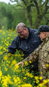seed specialist David Watson examines oilseed rape crop with farmer